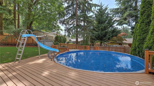 12350 SE 96th Pl, Renton, WA 98056 - view of swimming pool with a water slide, a fenced backyard, and a storage unit