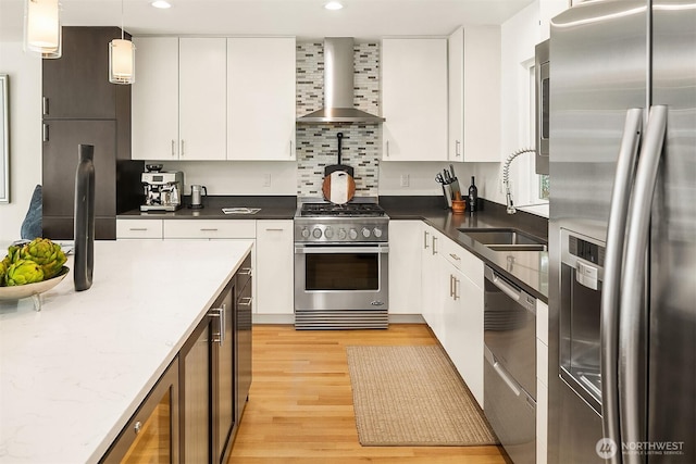 527 16th Ave W, Kirkland, WA 98033 - kitchen featuring appliances with stainless steel finishes, wall chimney range hood, light wood-type flooring, white cabinets, and recessed lighting