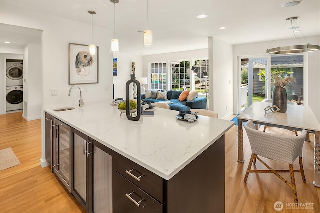527 16th Ave W, Kirkland, WA 98033 - kitchen with stacked washer / dryer, light wood-type flooring, wine cooler, dark brown cabinetry, and recessed lighting