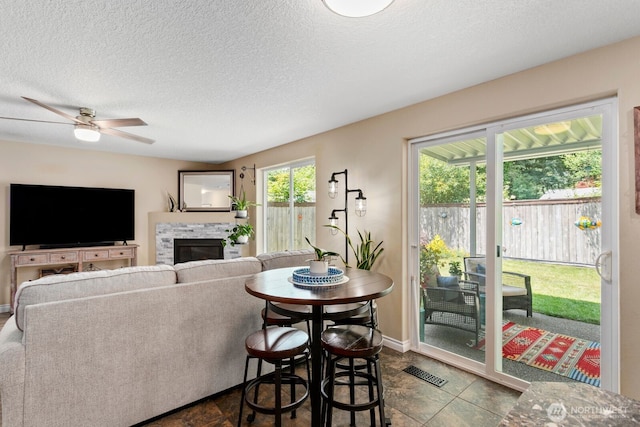 14908 NE 70th St, Vancouver, WA 98682 - living room with a ceiling fan, a glass covered fireplace, and a textured ceiling