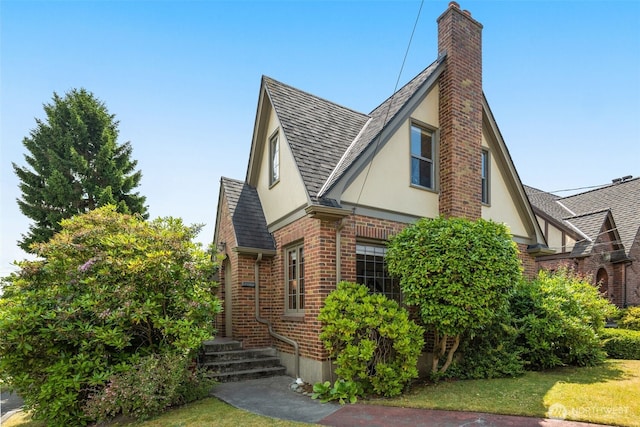 1157 N 78th St, Seattle, WA 98103 - view of front facade featuring stucco siding, a shingled roof, brick siding, and a chimney