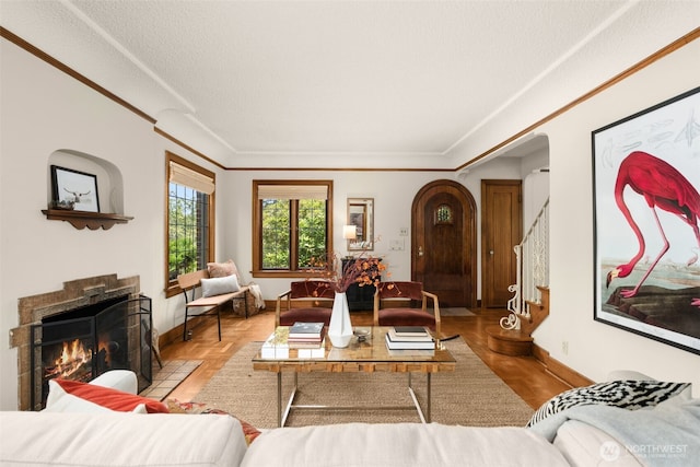 1157 N 78th St, Seattle, WA 98103 - living room with arched walkways, ornamental molding, a fireplace with flush hearth, a textured ceiling, and stairway