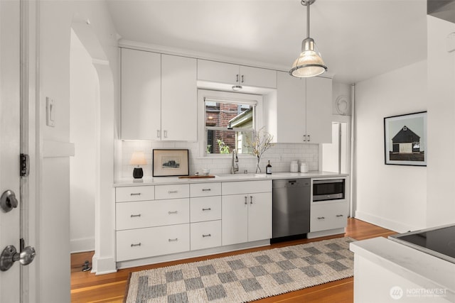 1157 N 78th St, Seattle, WA 98103 - kitchen featuring appliances with stainless steel finishes, light countertops, backsplash, and white cabinets