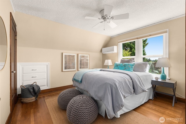 1157 N 78th St, Seattle, WA 98103 - bedroom with a wall unit AC, wood finished floors, a textured ceiling, vaulted ceiling, and ceiling fan