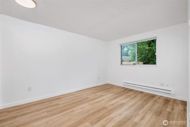 7509 E F St, Tacoma, WA 98404 - empty room with baseboard heating, wood finished floors, and a textured ceiling