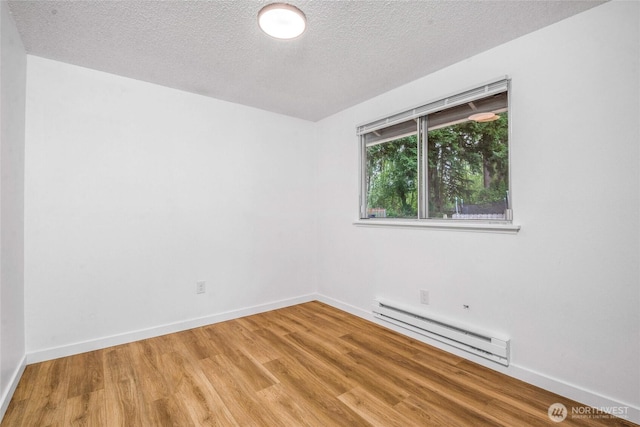 7509 E F St, Tacoma, WA 98404 - unfurnished room featuring baseboard heating, light wood-type flooring, and a textured ceiling