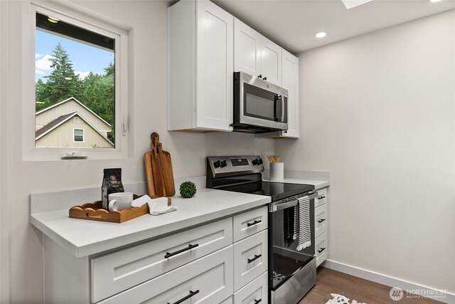 754 SW Oak Rd, Port Orchard, WA 98367 - kitchen featuring appliances with stainless steel finishes, light countertops, wood finished floors, white cabinetry, and recessed lighting