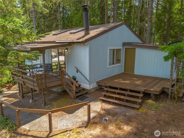 1681 E Saint Andrews Dr N, Shelton, WA 98584 - rear view of house with a deck, a shingled roof, and a chimney