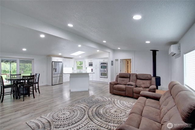7493 State Route 9, Sedro Woolley, WA 98284 - living room with a wood stove, lofted ceiling, an AC wall unit, light wood-style floors, and recessed lighting