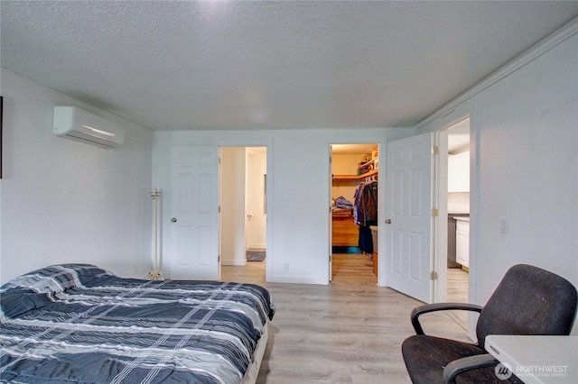 7493 State Route 9, Sedro Woolley, WA 98284 - bedroom featuring an AC wall unit, light wood finished floors, a spacious closet, a closet, and a textured ceiling