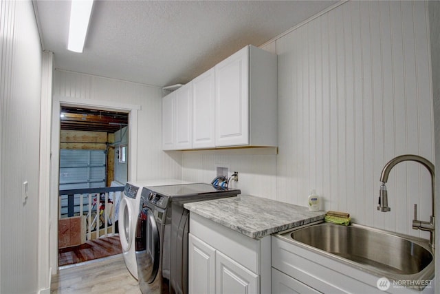 7493 State Route 9, Sedro Woolley, WA 98284 - washroom featuring cabinet space, washer and clothes dryer, light wood-style floors, a textured ceiling, and wooden walls