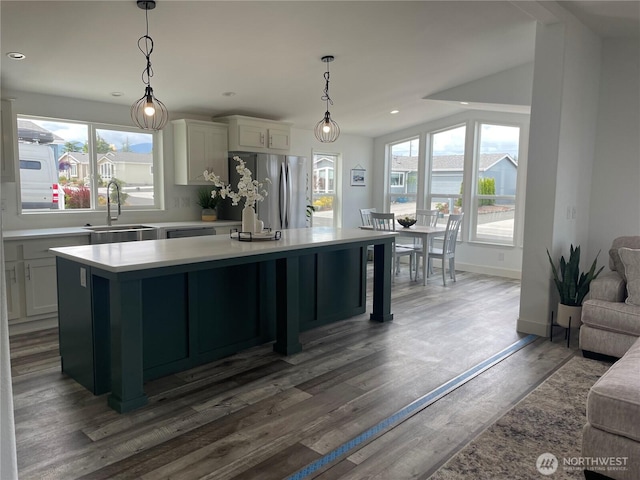 926 N Rock Rose Ave, Sequim, WA 98382 - kitchen featuring freestanding refrigerator, light countertops, a kitchen island, hanging light fixtures, and wood finished floors
