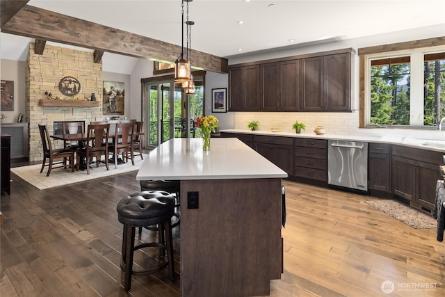 151 Miners Camp Way, Cle Elum, WA 98922 - kitchen featuring stainless steel dishwasher, dark brown cabinetry, light countertops, a breakfast bar area, and light wood-type flooring