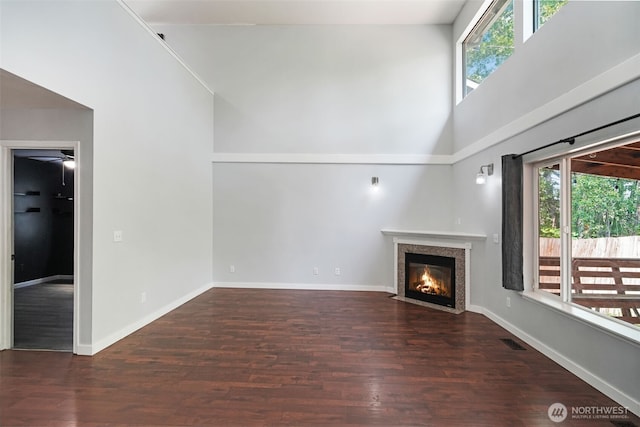 1407 196th St E, Spanaway, WA 98387 - unfurnished living room featuring a fireplace with flush hearth, healthy amount of natural light, a high ceiling, wood finished floors, and ceiling fan