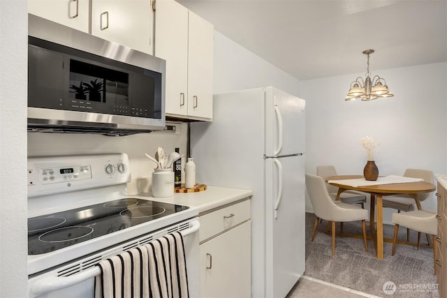 19428 Aurora Ave N Unit 427, Shoreline, WA 98133 - kitchen featuring white appliances, a chandelier, light countertops, hanging light fixtures, and white cabinetry