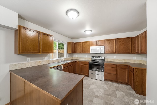 4817 S 251st Ct, Kent, WA 98032 - kitchen with appliances with stainless steel finishes, brown cabinetry, and a peninsula