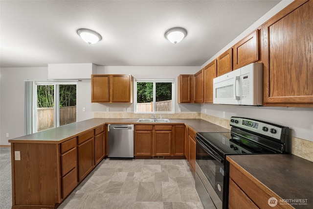 4817 S 251st Ct, Kent, WA 98032 - kitchen featuring stainless steel appliances, a peninsula, brown cabinets, and plenty of natural light