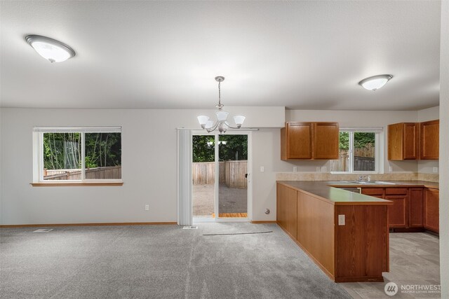 4817 S 251st Ct, Kent, WA 98032 - kitchen with brown cabinetry, healthy amount of natural light, and a chandelier