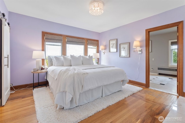 1116 N J St, Tacoma, WA 98403 - bedroom with radiator, light wood-style floors, a chandelier, and a barn door