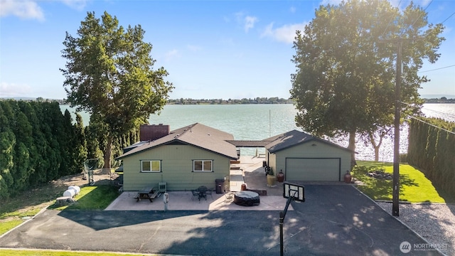 2102 NE Elgin Rd, Moses Lake, WA 98837 - view of front facade featuring a detached garage, a water view, an outdoor structure, and a front lawn