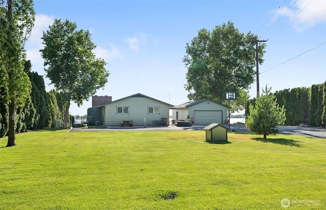 2102 NE Elgin Rd, Moses Lake, WA 98837 - view of green lawn featuring a garage and a storage shed