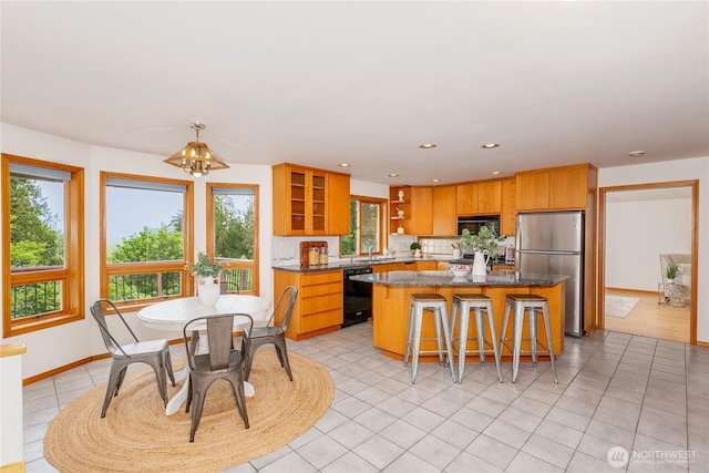 7401 E Heather Way, Everett, WA 98203 - kitchen featuring freestanding refrigerator, black dishwasher, a center island, a kitchen bar, and tasteful backsplash