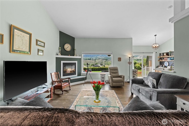 2835 Aspen Shores Dr, East Wenatchee, WA 98802 - living area featuring a glass covered fireplace, wood finished floors, a chandelier, and lofted ceiling