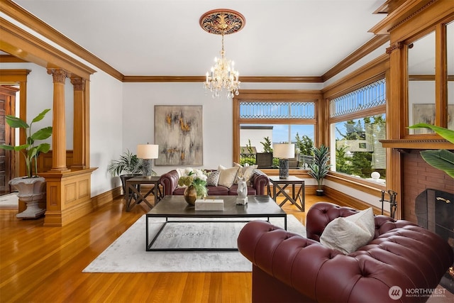 1214 Warren Ave N, Seattle, WA 98109 - living room with wood finished floors, crown molding, a chandelier, and decorative columns