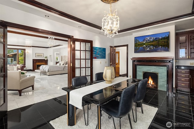 1214 Warren Ave N, Seattle, WA 98109 - dining room featuring a lit fireplace, crown molding, and a chandelier