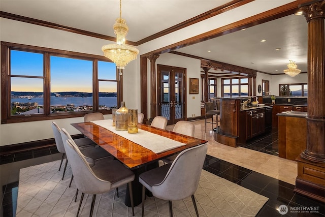 1214 Warren Ave N, Seattle, WA 98109 - dining space with crown molding, a chandelier, french doors, recessed lighting, and decorative columns