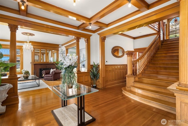 1214 Warren Ave N, Seattle, WA 98109 - living room featuring decorative columns, stairway, wood finished floors, beam ceiling, and wainscoting