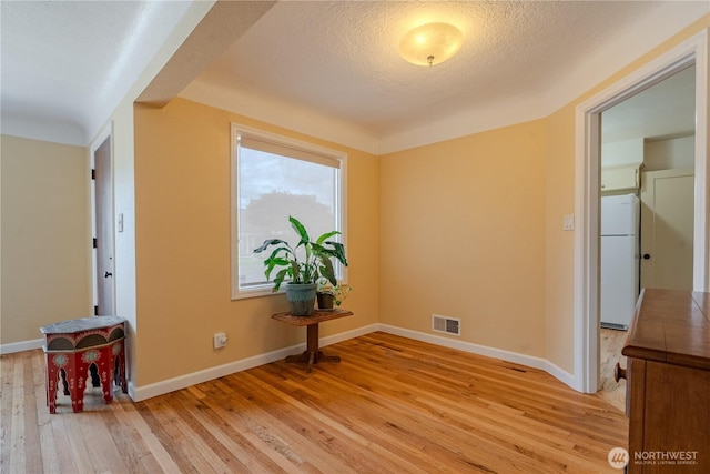 1028 20th Ave, Longview, WA 98632 - empty room with light wood finished floors and a textured ceiling