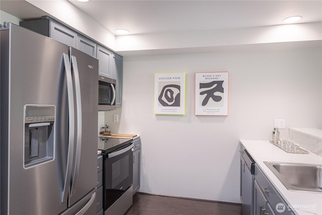 559 Mcgraw St Unit 204, Seattle, WA 98109 - kitchen with stainless steel appliances, dark wood-style floors, light countertops, gray cabinetry, and recessed lighting