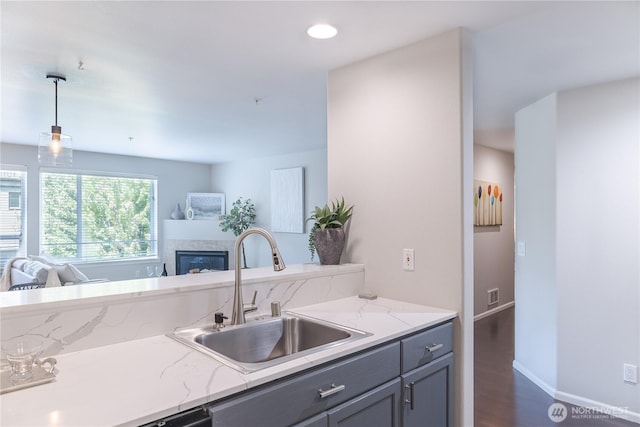 559 Mcgraw St Unit 204, Seattle, WA 98109 - kitchen with open floor plan, gray cabinets, dark wood-style flooring, decorative light fixtures, and a glass covered fireplace