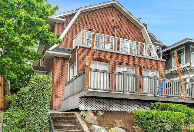 4715 19th Ave NE, Seattle, WA 98105 - back of property with a balcony, brick siding, a gambrel roof, and a chimney