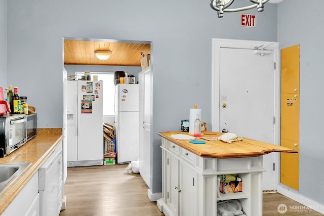 4715 19th Ave NE, Seattle, WA 98105 - kitchen featuring white fridge with ice dispenser, freestanding refrigerator, wooden ceiling, white cabinets, and light wood finished floors