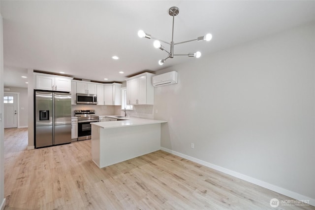 8256 Gold Run Dr, Maple Falls, WA 98266 - kitchen featuring stainless steel appliances, a wall unit AC, a peninsula, light wood-style flooring, and recessed lighting