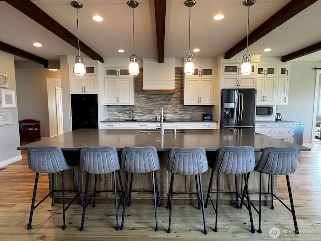 12003 Summit Haven Pl, Yakima, WA 98908 - kitchen with refrigerator with ice dispenser, stainless steel microwave, beamed ceiling, backsplash, and light wood finished floors