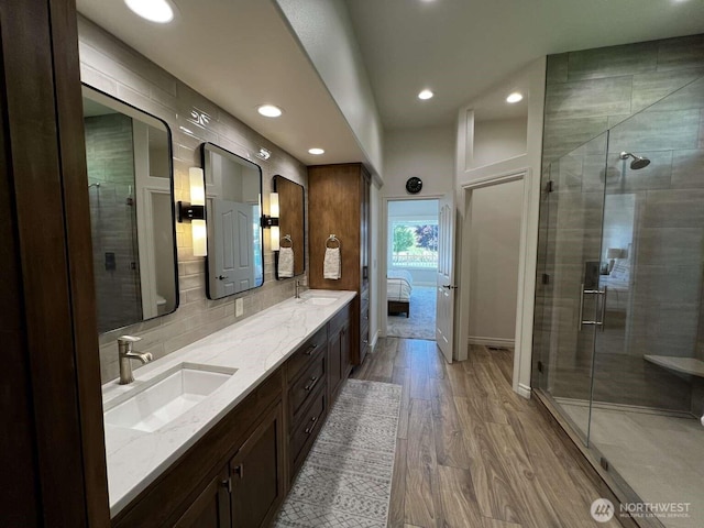 12003 Summit Haven Pl, Yakima, WA 98908 - ensuite bathroom featuring recessed lighting, double vanity, wood finished floors, a stall shower, and decorative backsplash