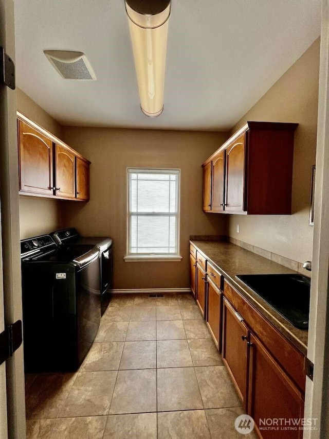 12003 Summit Haven Pl, Yakima, WA 98908 - laundry area featuring cabinet space, washer and clothes dryer, and light tile patterned floors