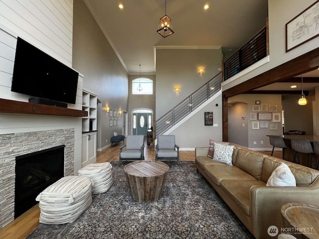 12003 Summit Haven Pl, Yakima, WA 98908 - living room featuring a towering ceiling, crown molding, wood finished floors, a stone fireplace, and arched walkways