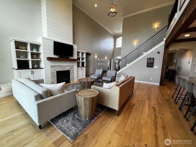 12003 Summit Haven Pl, Yakima, WA 98908 - living area featuring a towering ceiling, arched walkways, a stone fireplace, wood finished floors, and ornamental molding