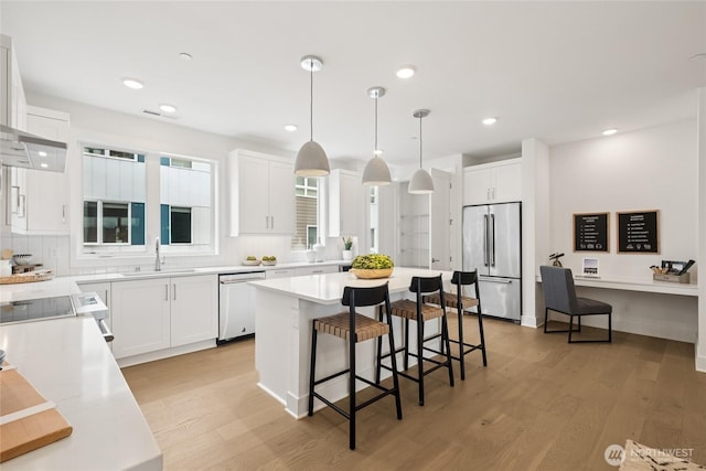 12257 137th Pl NE Unit 2901, Redmond, WA 98052 - kitchen featuring stainless steel appliances, a breakfast bar, backsplash, light wood finished floors, and a kitchen island