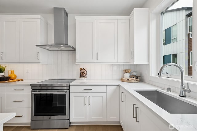 12257 137th Pl NE Unit 2901, Redmond, WA 98052 - kitchen with wall chimney exhaust hood, electric stove, decorative backsplash, and white cabinets