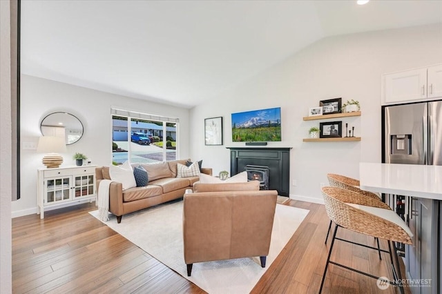 26908 NE Bird St, Duvall, WA 98019 - living area with vaulted ceiling, light wood finished floors, and a lit fireplace