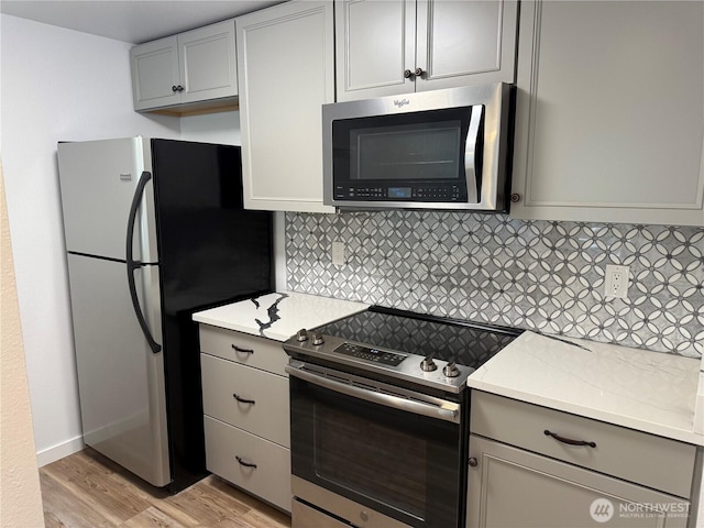 509 S 323rd Pl Unit 15E, Federal Way, WA 98003 - kitchen featuring appliances with stainless steel finishes, gray cabinets, light wood-type flooring, and tasteful backsplash