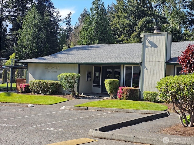 509 S 323rd Pl Unit 15E, Federal Way, WA 98003 - view of front of home featuring uncovered parking, a chimney, a shingled roof, and a front lawn