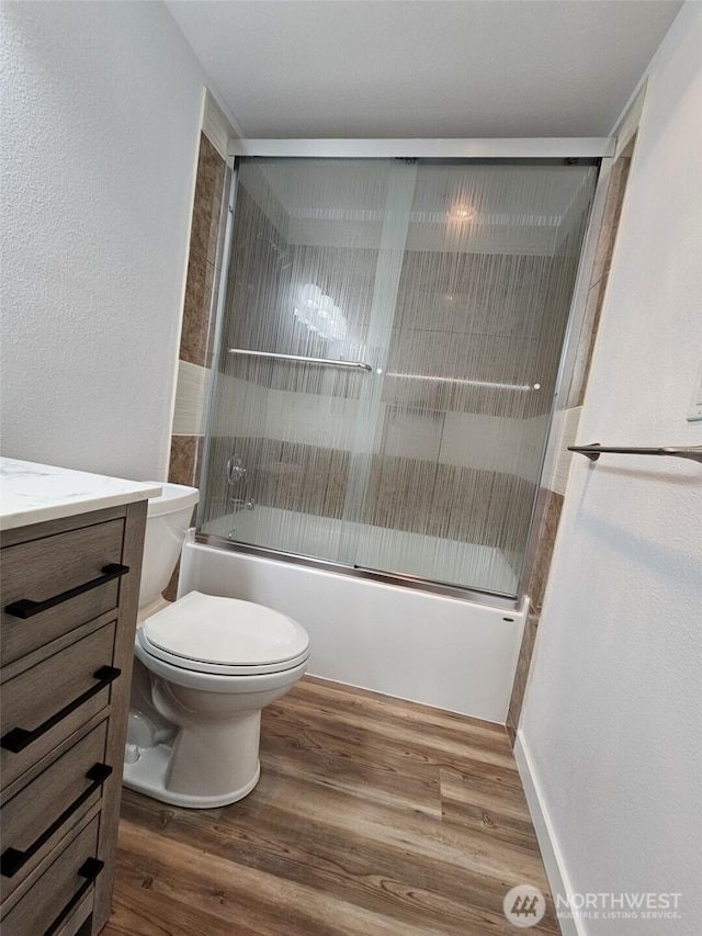509 S 323rd Pl Unit 15E, Federal Way, WA 98003 - full bathroom featuring wood finished floors, enclosed tub / shower combo, vanity, and a textured wall