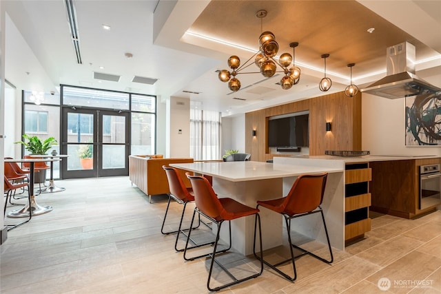 1085 103rd Ave NE Unit 217, Bellevue, WA 98004 - kitchen with island exhaust hood, light countertops, light wood-style floors, oven, and a wall of windows
