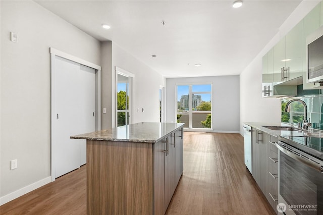 1085 103rd Ave NE Unit 217, Bellevue, WA 98004 - kitchen with modern cabinets, wood finished floors, a center island, stainless steel electric stove, and white dishwasher